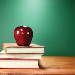 stock image of red apple on three books